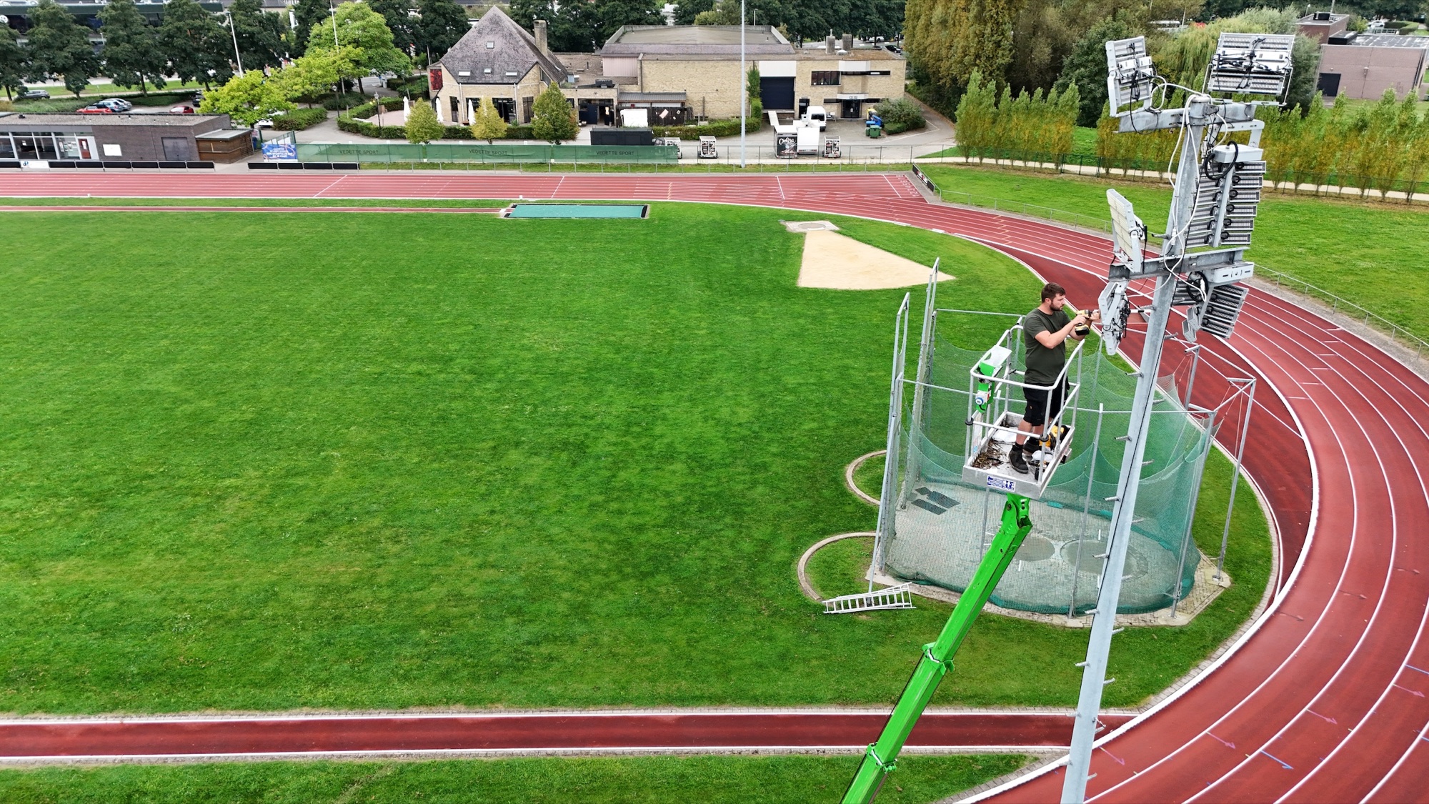 Onderhoud aan de atletiekverlichting vanuit de hoogwerker