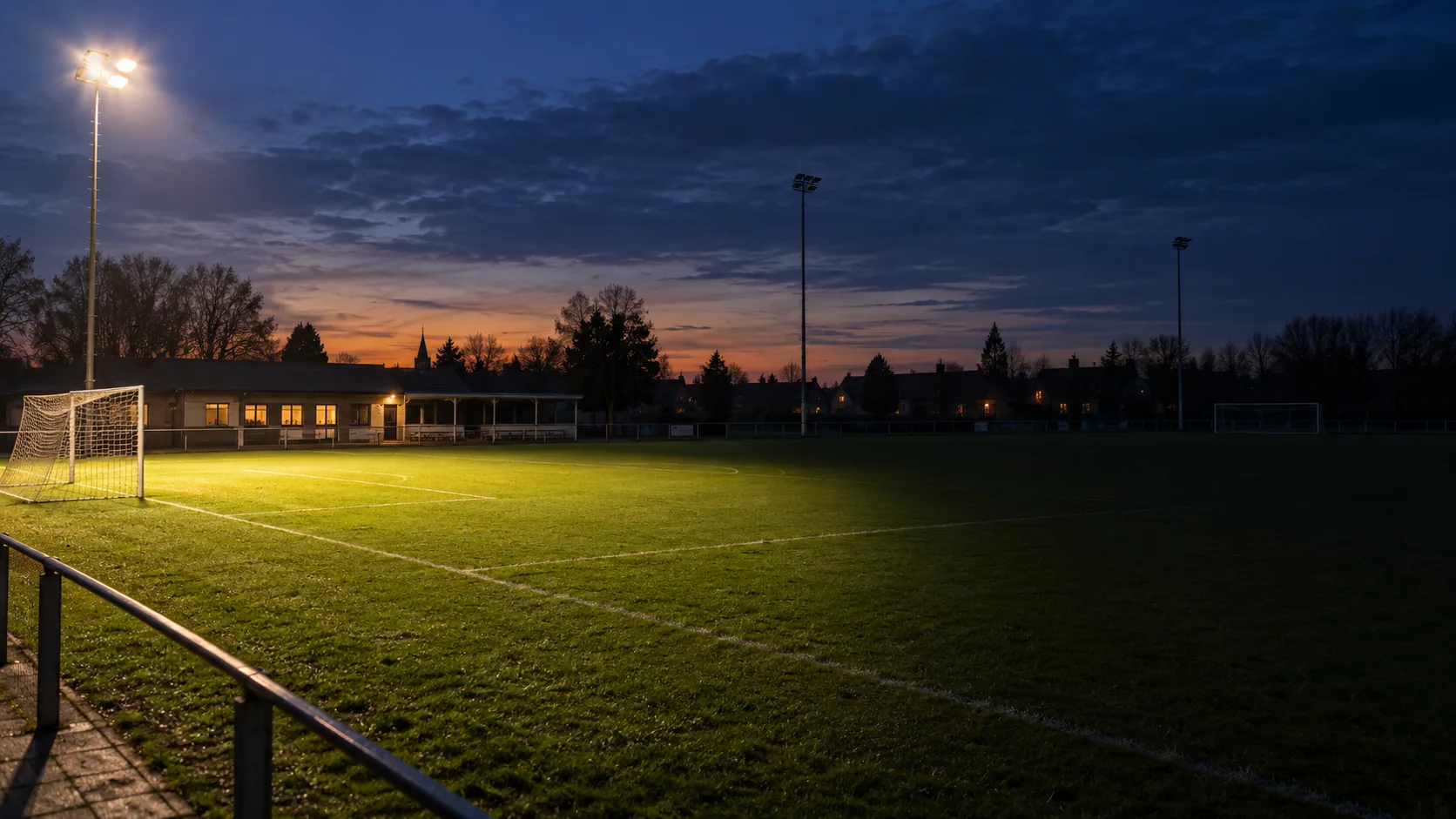 Illustratie van een voetbalveld waarvan slechts een deel verlicht is bij valavond