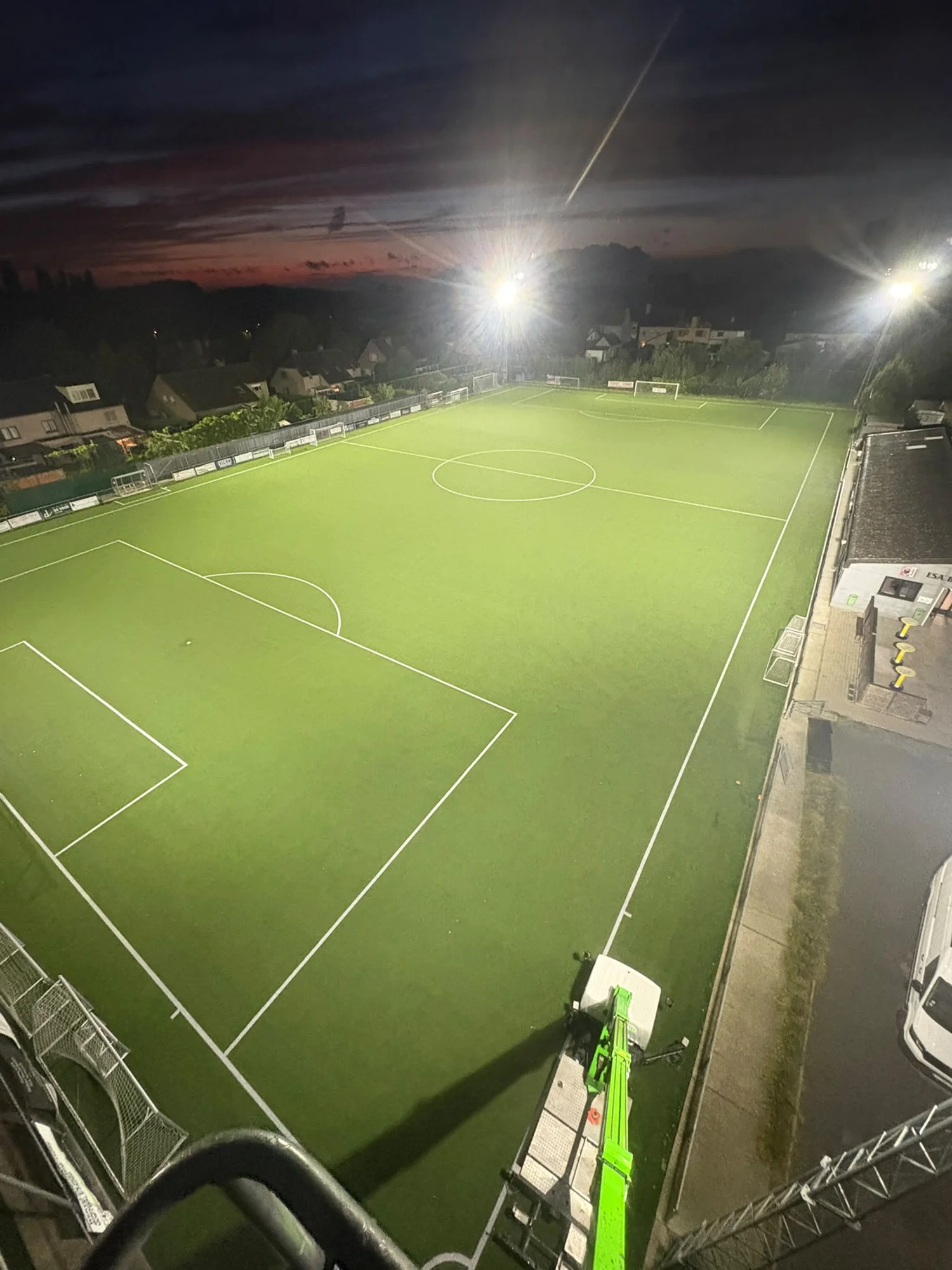 Het verlichte voetbalveld van ESA Bottelare bij avond