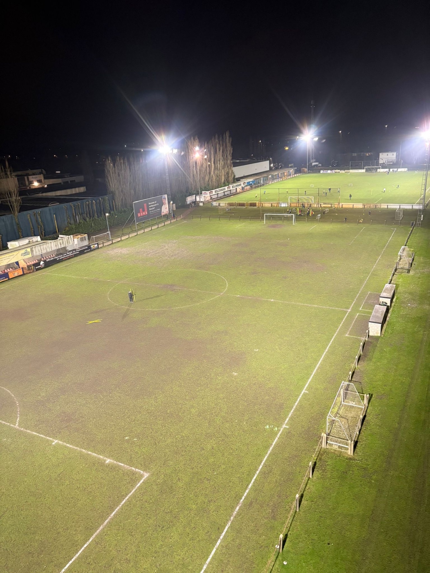 Avondzicht over het verlichte voetbalterrein bij K. Brecht SK