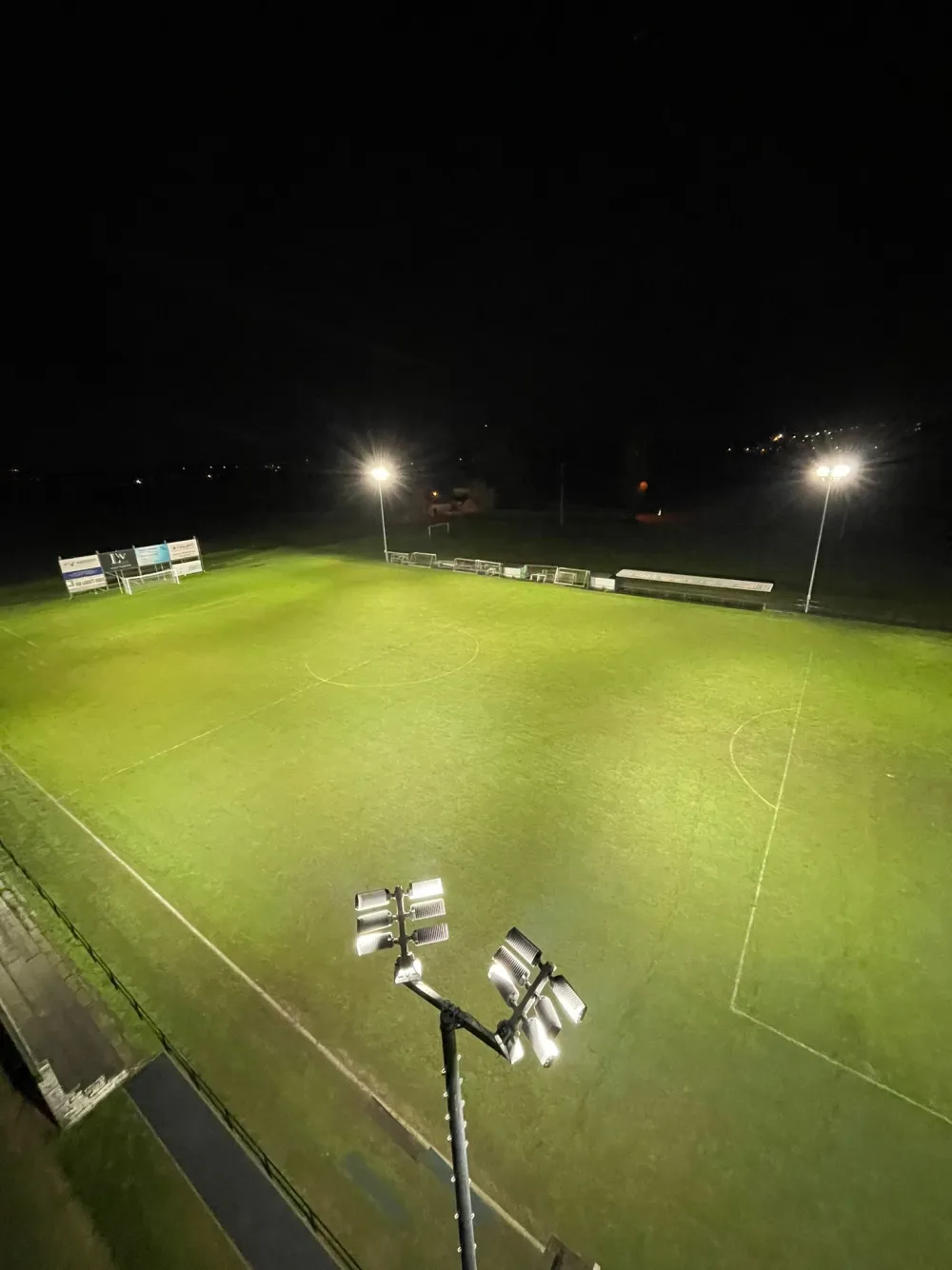Overzicht van het verlichte voetbalveld vanuit de hoogte