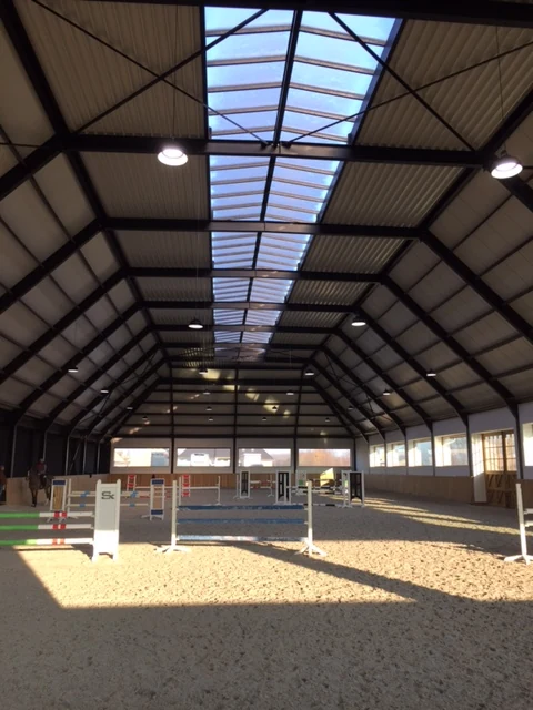 Overzicht van de verlichte rijhal bij Stephex Stables
