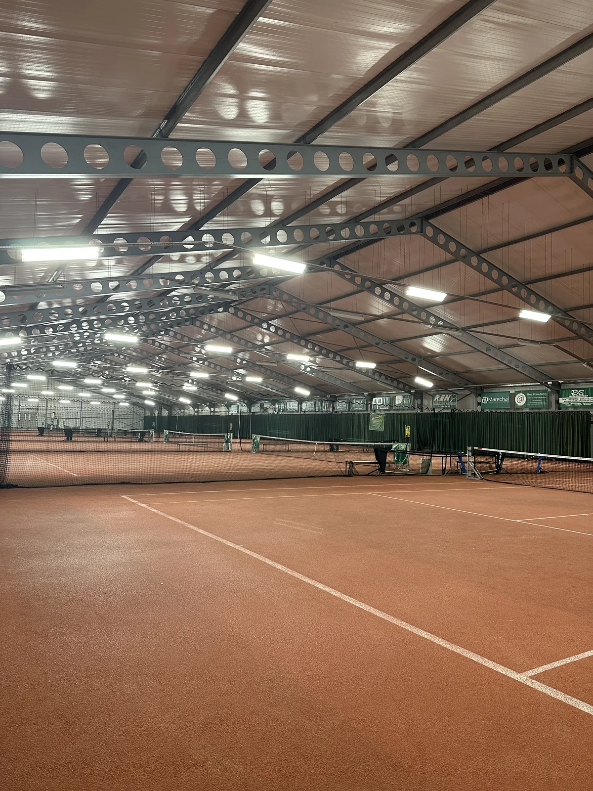 De verlichte indoor tennisbanen en plafondarmaturen bij TP Tessenderlo