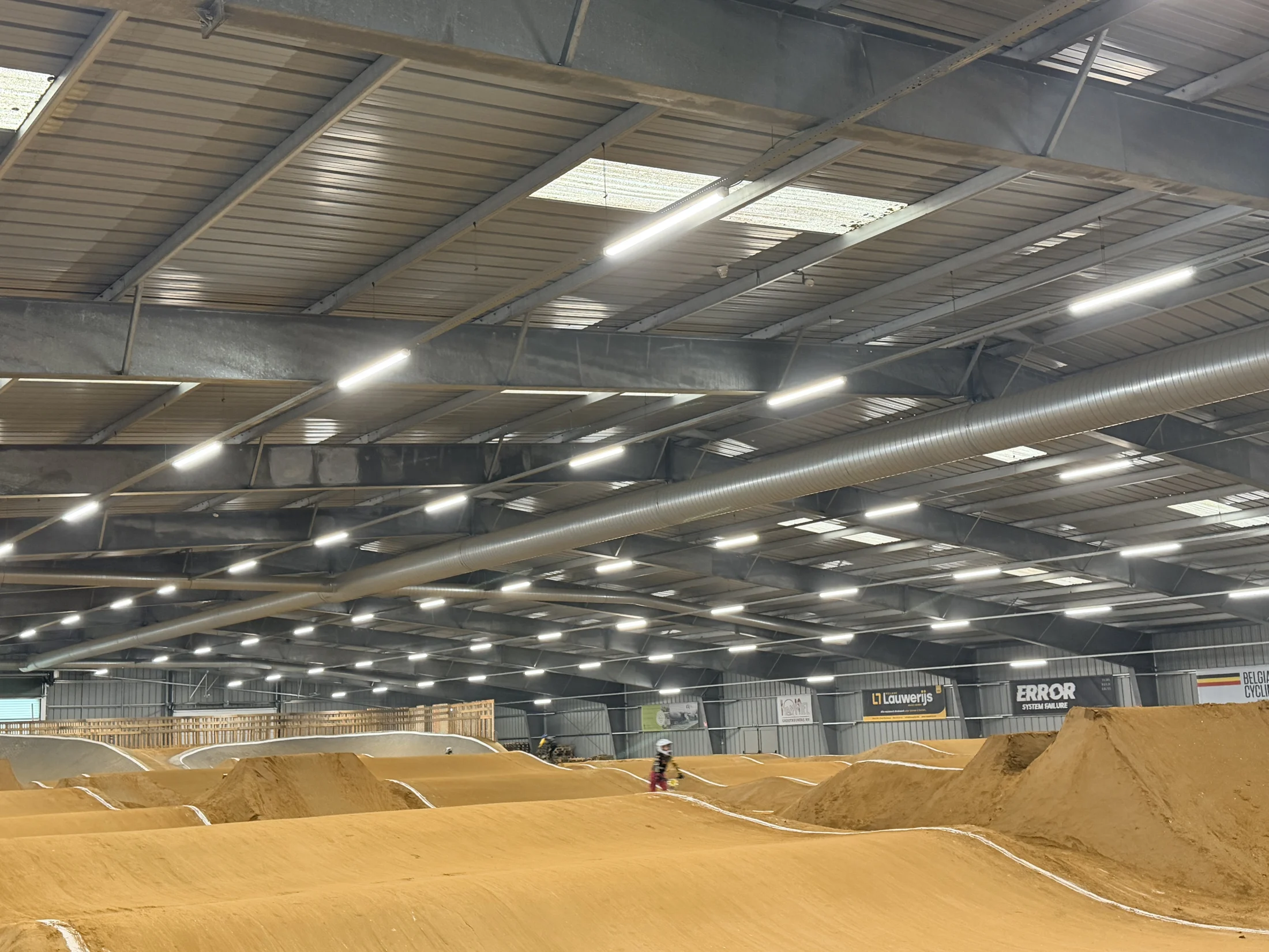Breed overzicht van het BMX-parcours van Triple 6 Base onder de LED-verlichting
