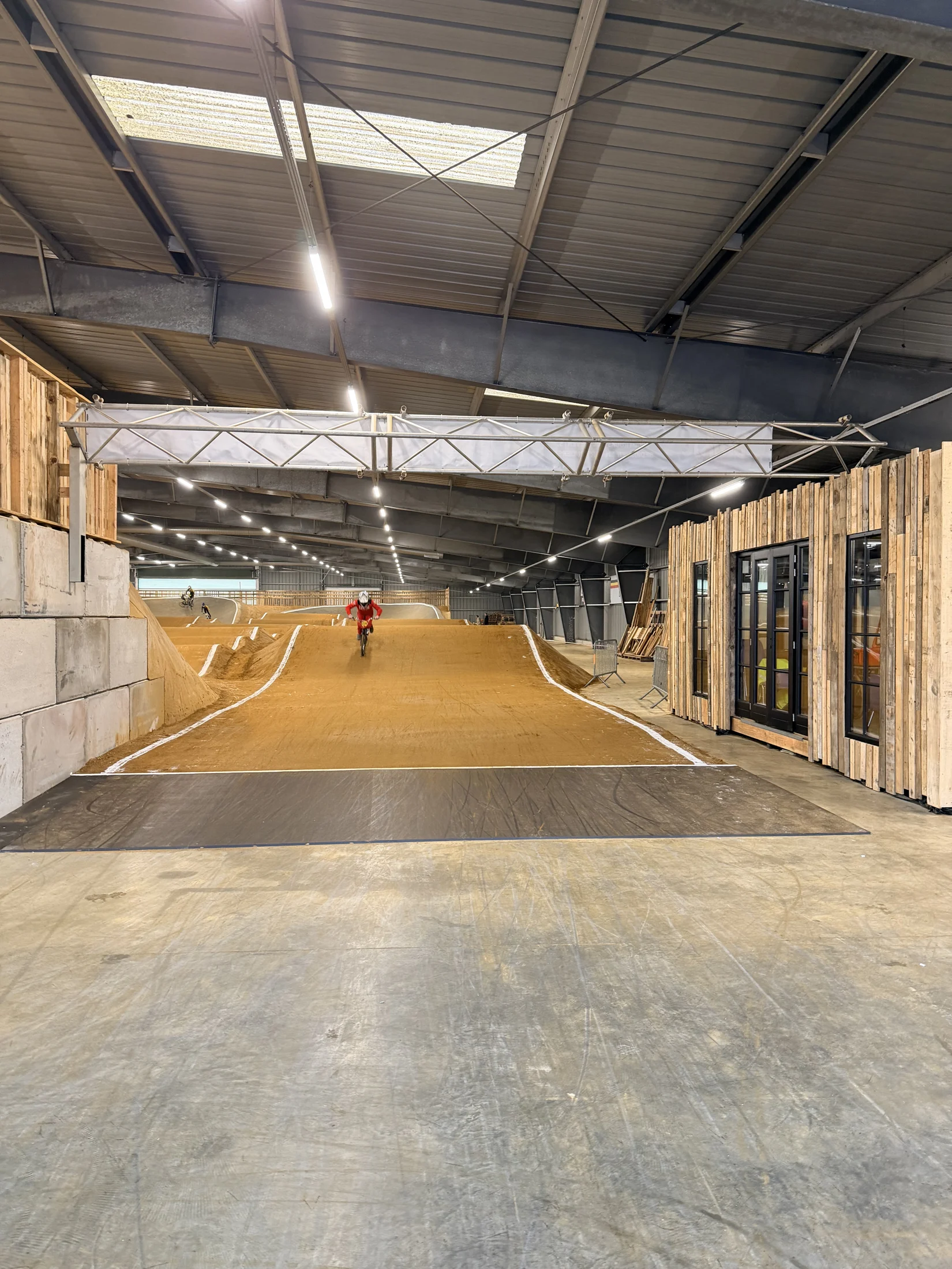 Zicht vanaf de startzone op de verlichte indoor BMX-baan van Triple 6 Base