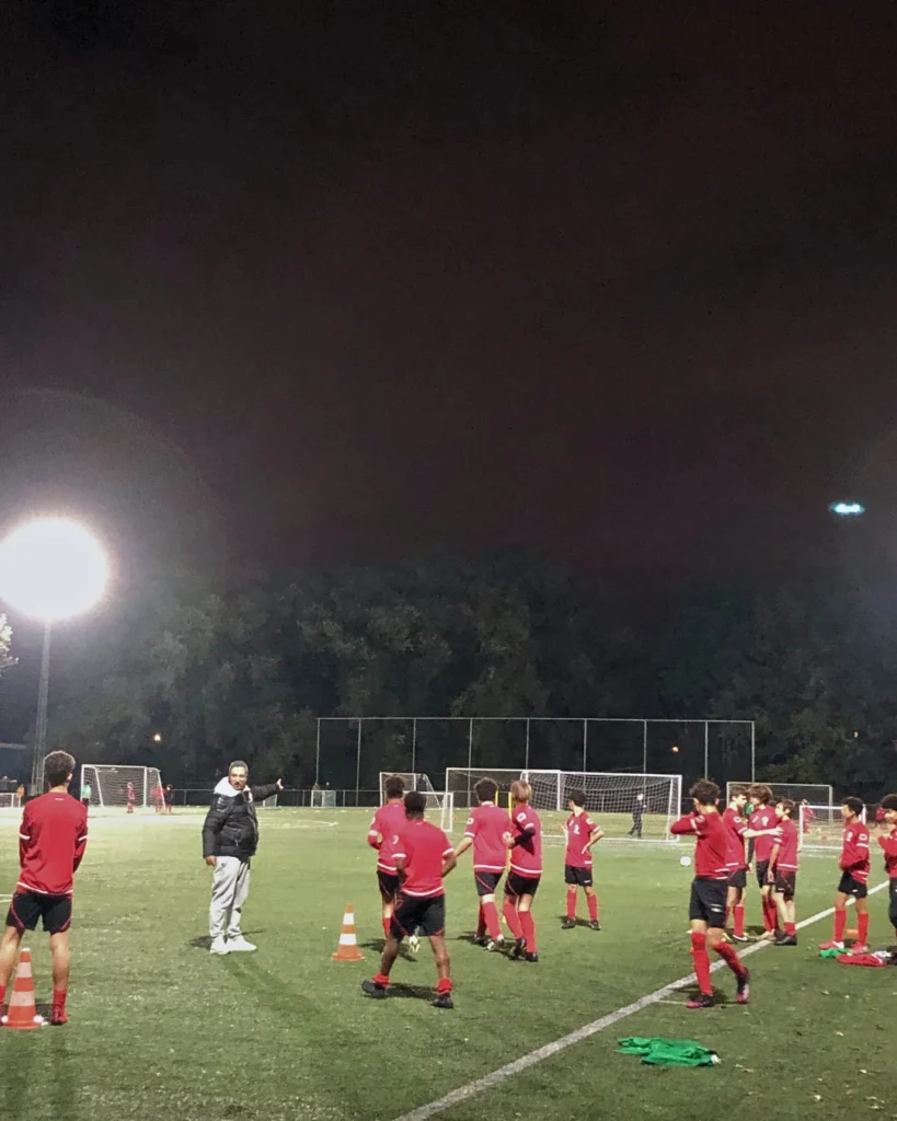 Evening training on a sports field lit by powerful LED fixtures with even and bright light