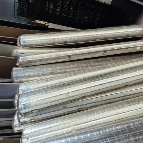 Stapel oude verouderde TL-verlichtingsarmaturen in afwachting van vervanging door LED in een sporthal