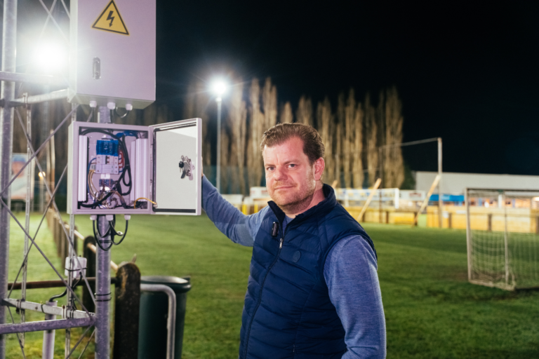 Medebestuurslid bij de open stuurkast van de LED-installatie