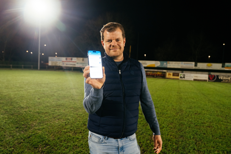 Medebestuurslid toont de EcoSports verlichtingsapp op het verlichte veld