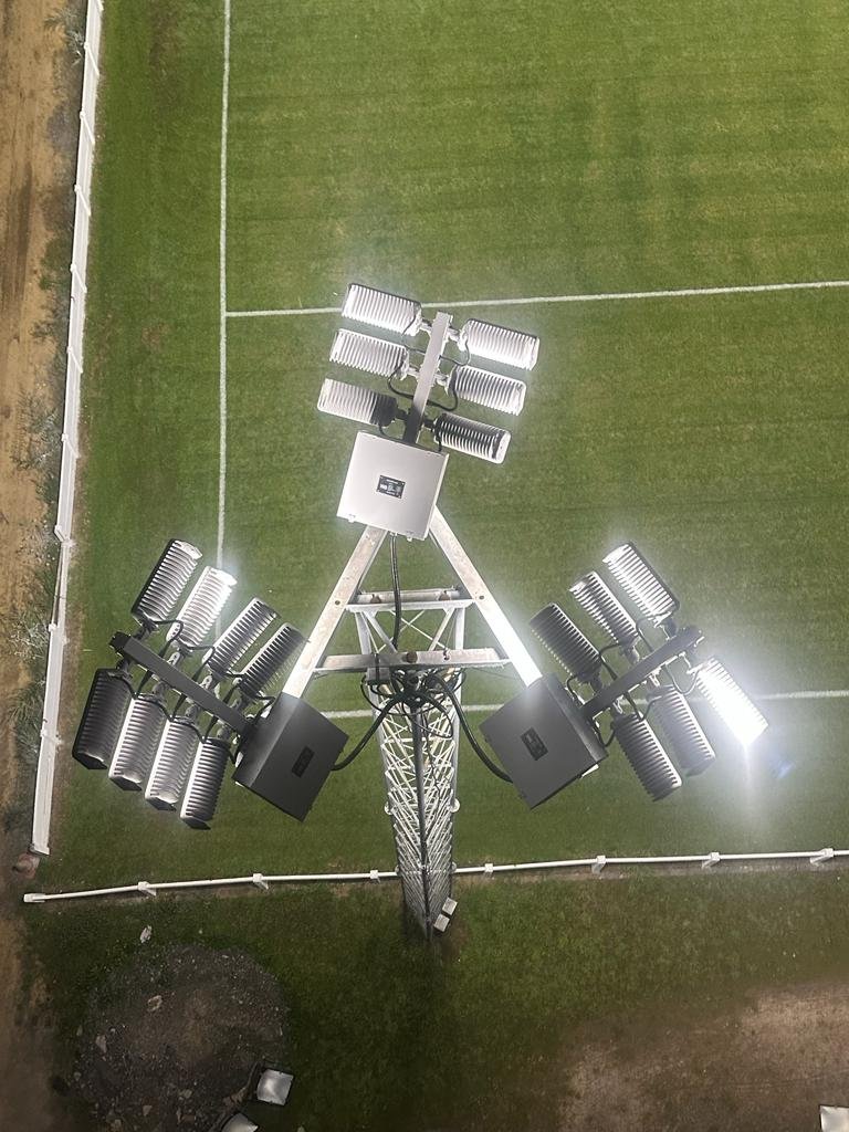 Bovenaanzicht van een LED-verlichtingsmast op een hockeyveld bij avond